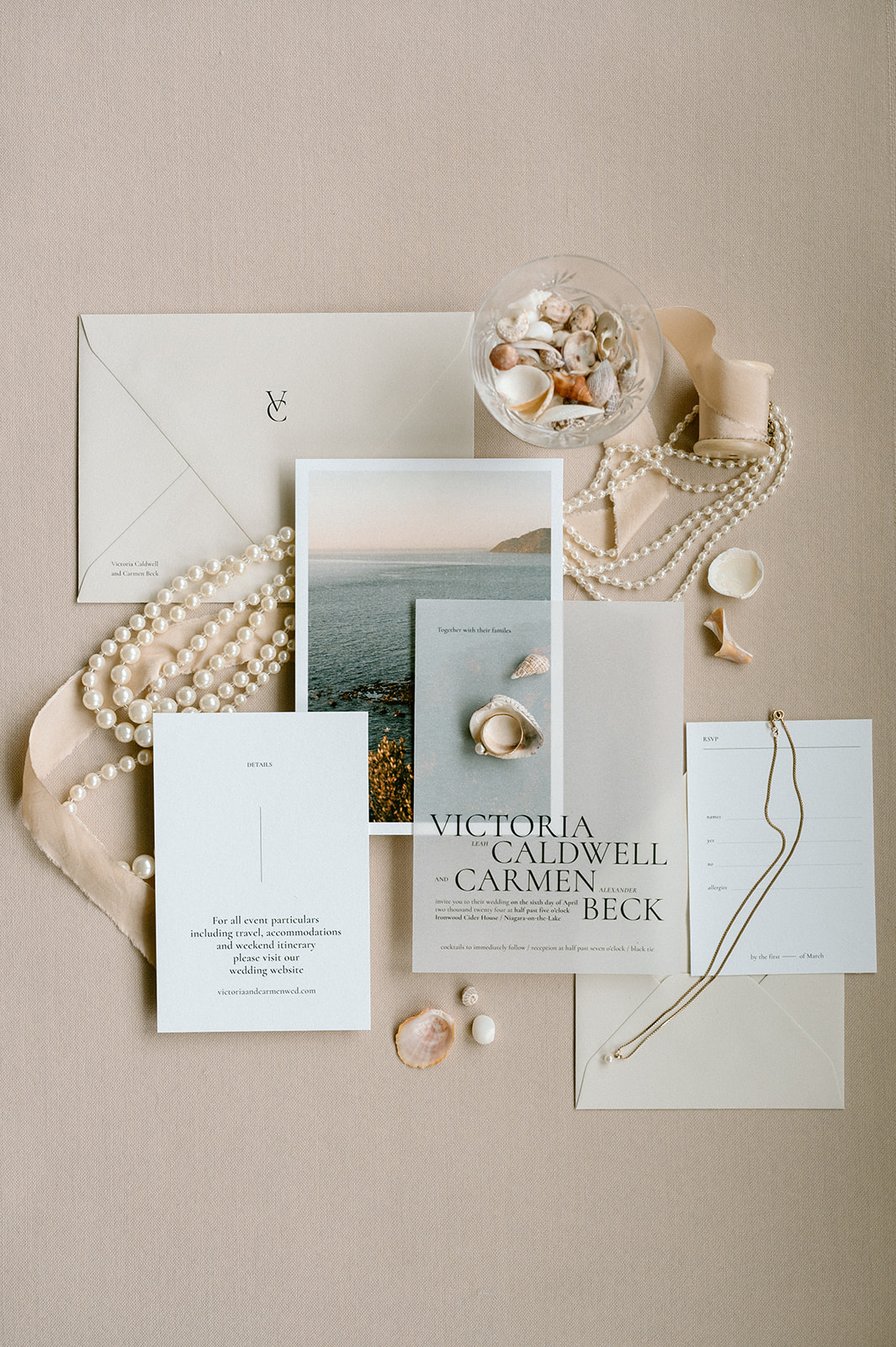 wedding stationery flat lay with pearls and gold accents, white and peach accent, modern wedding design